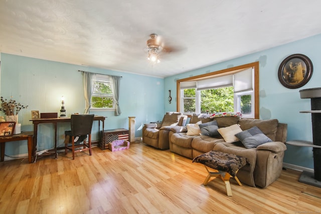 living room with light wood-type flooring, plenty of natural light, and ceiling fan