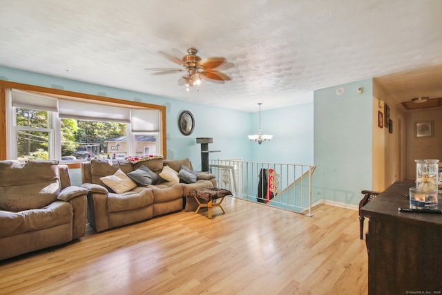 living room featuring light hardwood / wood-style flooring and ceiling fan with notable chandelier