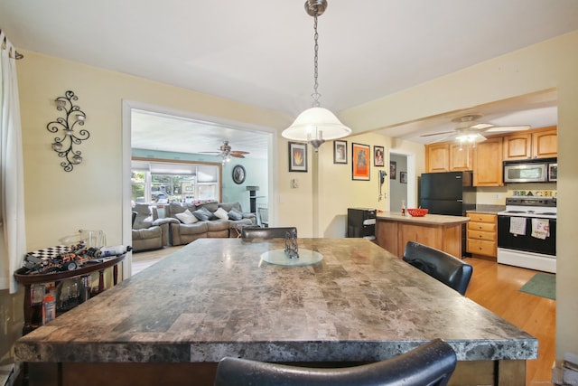 dining room with light wood-type flooring and ceiling fan