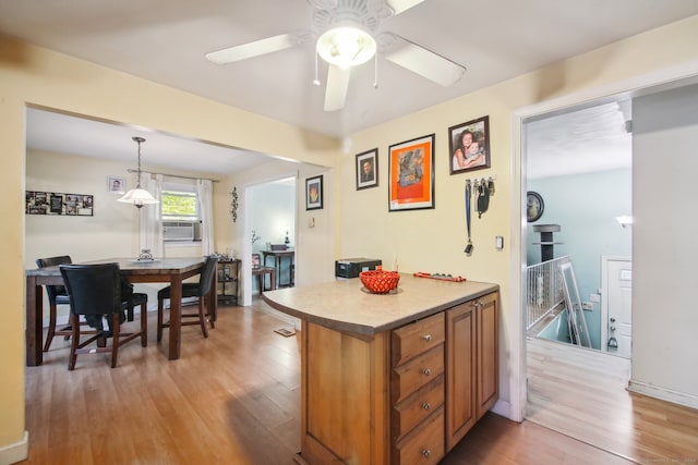 kitchen featuring light hardwood / wood-style floors, cooling unit, ceiling fan, and pendant lighting