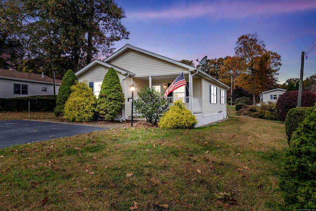 property exterior at dusk featuring a yard