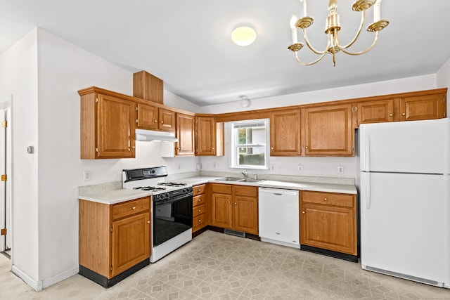 kitchen featuring lofted ceiling, sink, pendant lighting, a chandelier, and white appliances