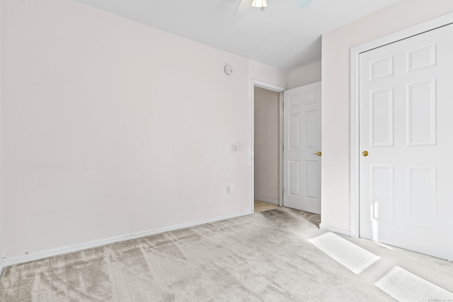 unfurnished bedroom with ceiling fan and light carpet