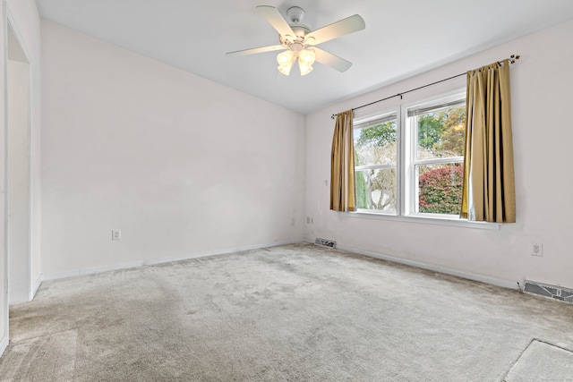 spare room featuring light colored carpet and ceiling fan