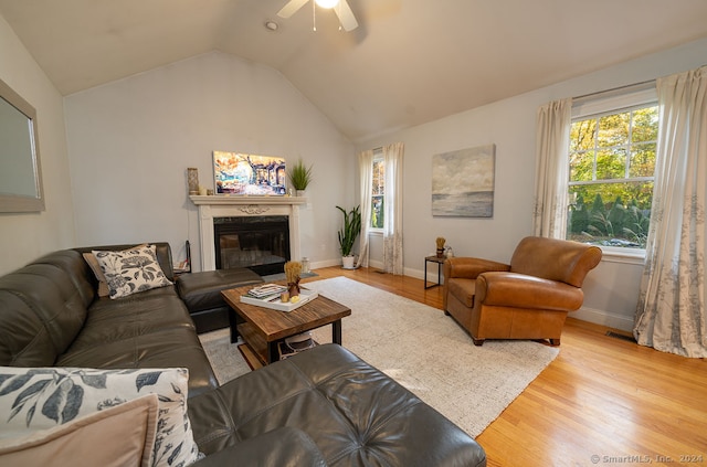 living room featuring lofted ceiling, light wood-type flooring, and ceiling fan