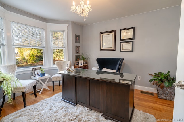 office area with an inviting chandelier and light hardwood / wood-style floors