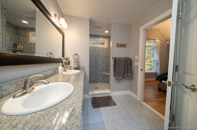 bathroom featuring vanity, tiled shower, and tile patterned flooring