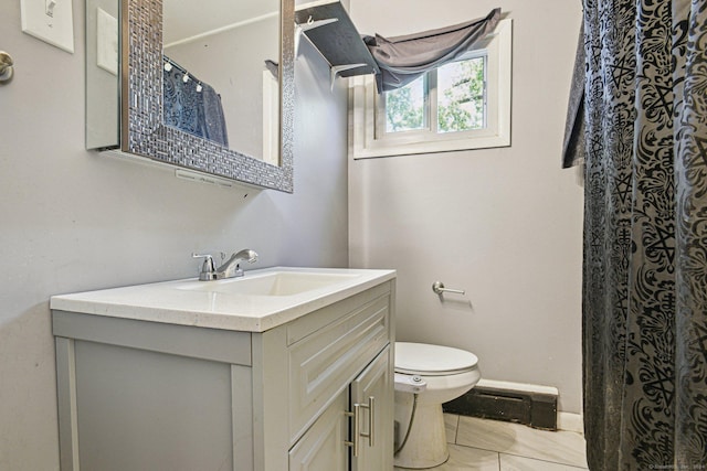 bathroom featuring tile patterned flooring, vanity, toilet, and curtained shower