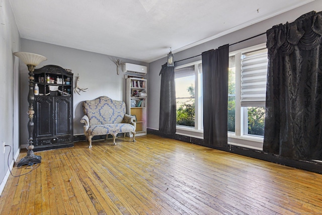 sitting room featuring a wall unit AC and light hardwood / wood-style flooring