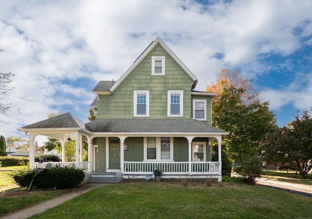 farmhouse inspired home featuring a front yard and covered porch