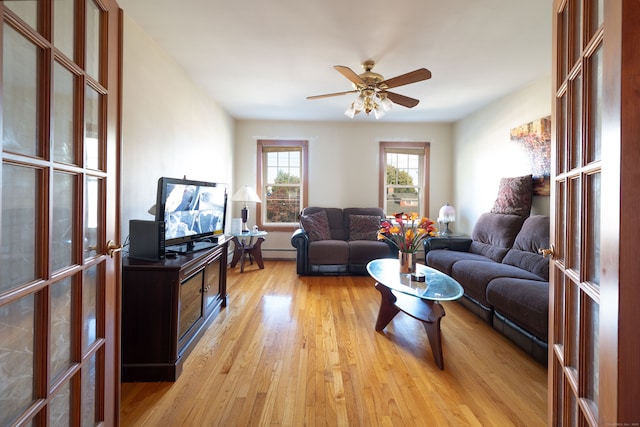 living room with light hardwood / wood-style floors and ceiling fan