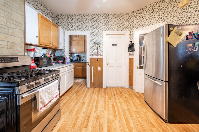 kitchen featuring appliances with stainless steel finishes, white cabinets, and light wood-type flooring