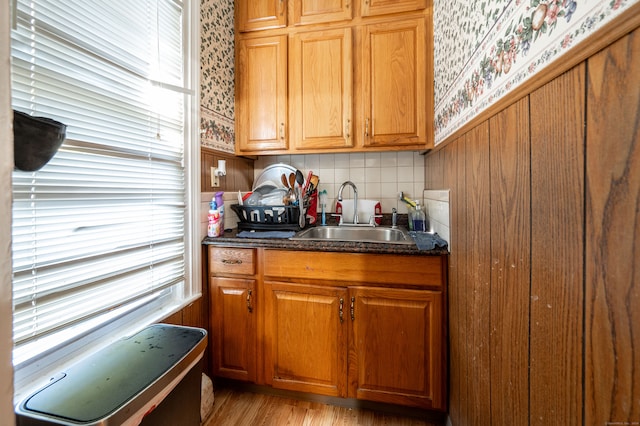 kitchen with backsplash, sink, and light wood-type flooring