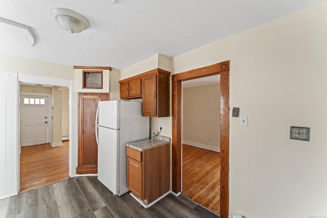 kitchen featuring a textured ceiling, white refrigerator, a baseboard radiator, and dark wood-type flooring