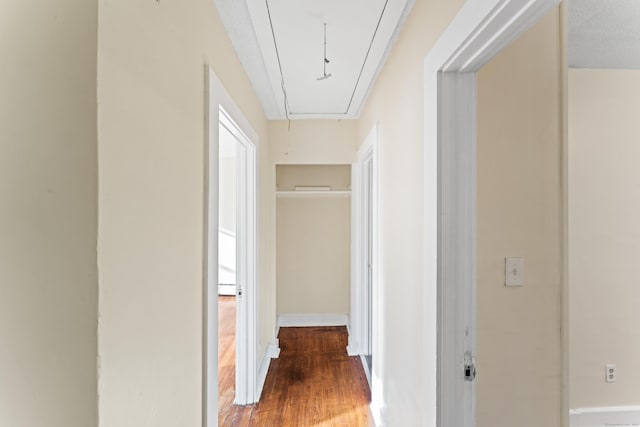 hall with wood-type flooring and a textured ceiling