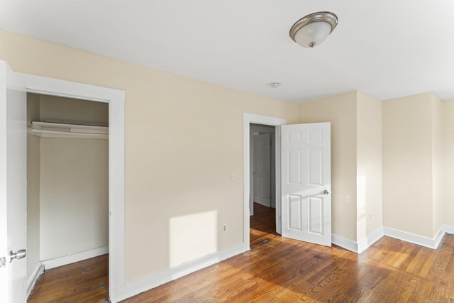 unfurnished bedroom featuring a closet and hardwood / wood-style flooring