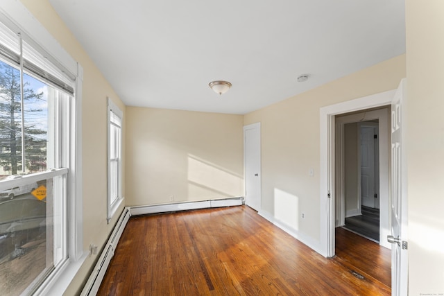 empty room featuring a baseboard radiator and dark hardwood / wood-style floors