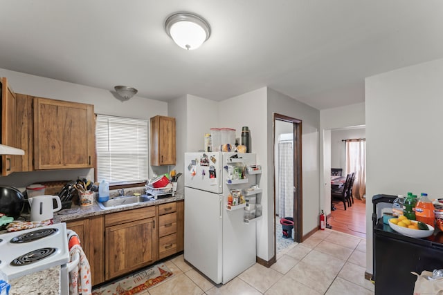 kitchen with white appliances, light tile patterned floors, and sink