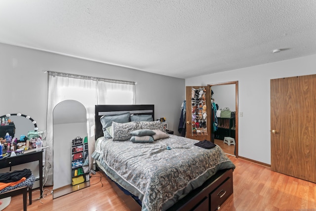 bedroom featuring a textured ceiling and light hardwood / wood-style floors