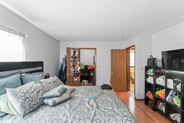 bedroom featuring light hardwood / wood-style flooring and a textured ceiling