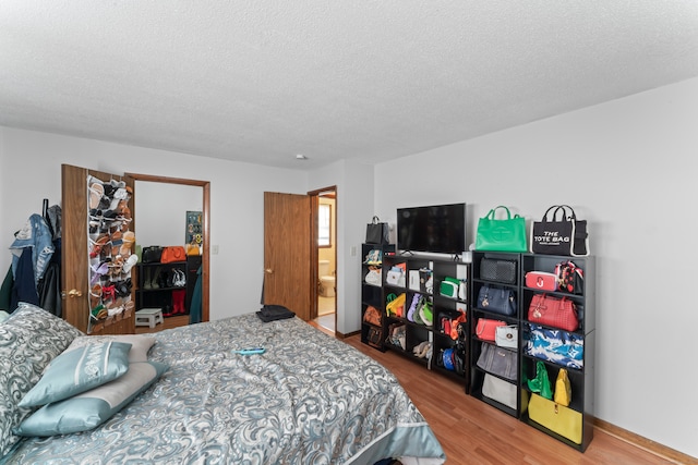 bedroom featuring a textured ceiling and wood-type flooring