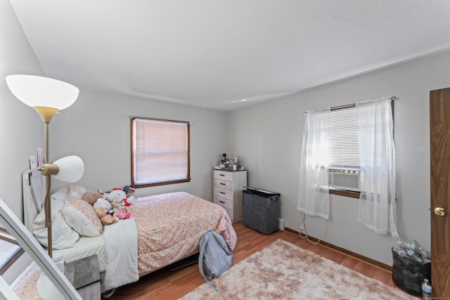 bedroom with light hardwood / wood-style flooring and cooling unit