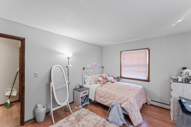 bedroom featuring light hardwood / wood-style floors and baseboard heating