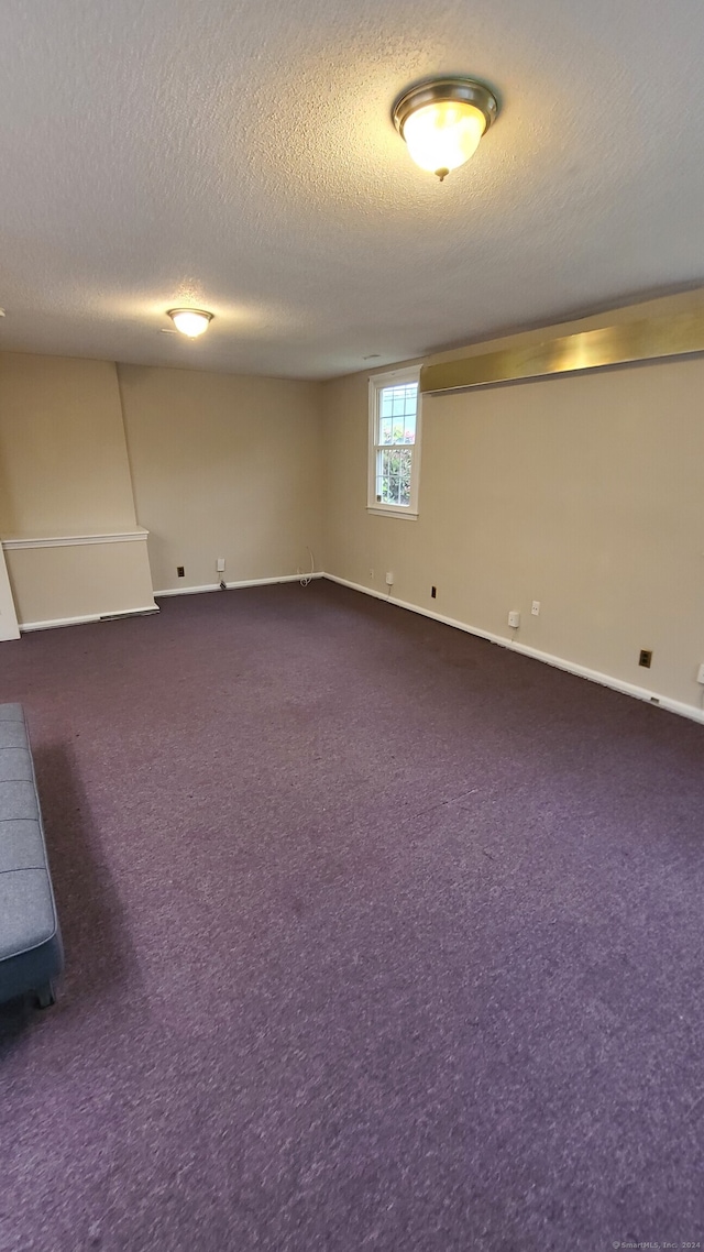 basement with dark carpet and a textured ceiling