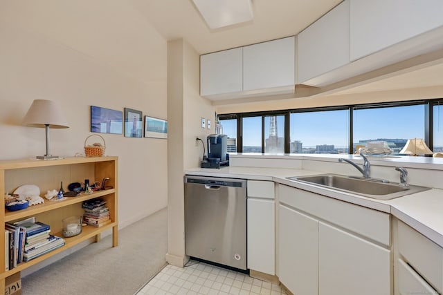 kitchen with stainless steel dishwasher, sink, white cabinets, and light colored carpet