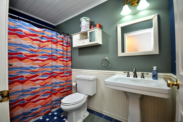 bathroom with toilet, ornamental molding, and a shower with curtain