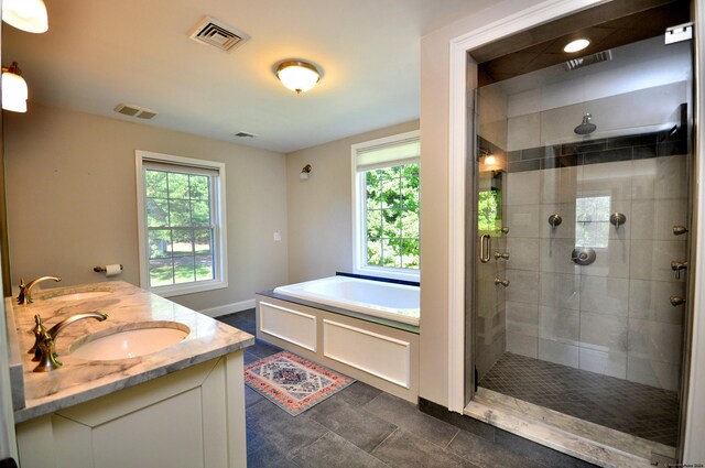 bathroom featuring vanity, a healthy amount of sunlight, shower with separate bathtub, and tile patterned flooring