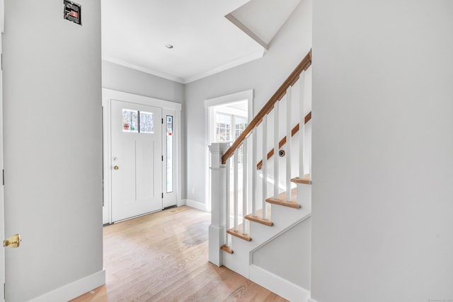 entrance foyer with ornamental molding and light wood-type flooring