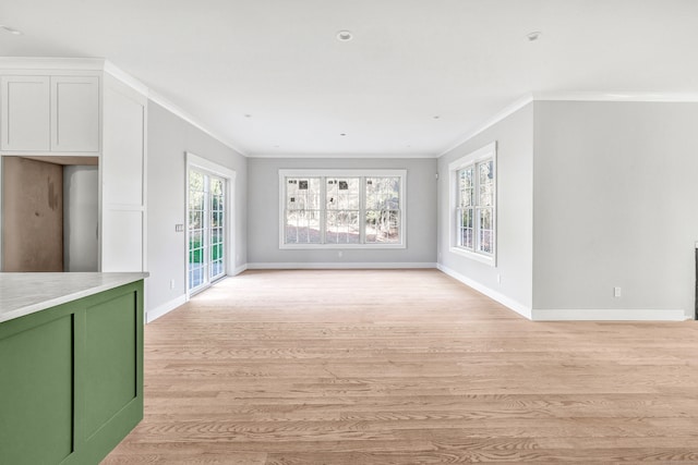 unfurnished living room with light hardwood / wood-style floors and crown molding