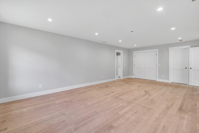 unfurnished bedroom with two closets and light hardwood / wood-style floors