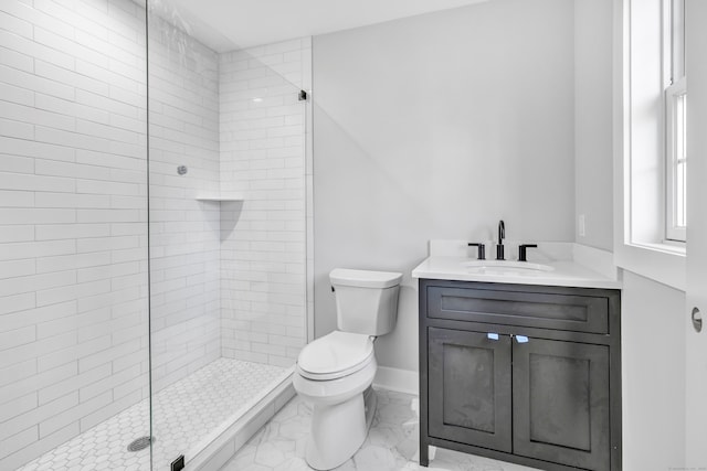 bathroom with vanity, toilet, and tiled shower