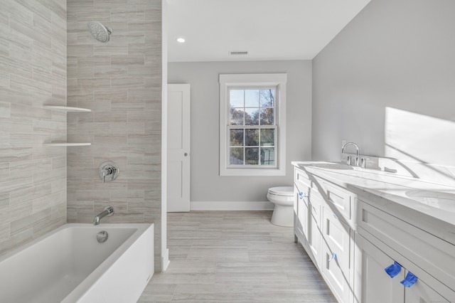 full bathroom with vanity, tiled shower / bath, and toilet