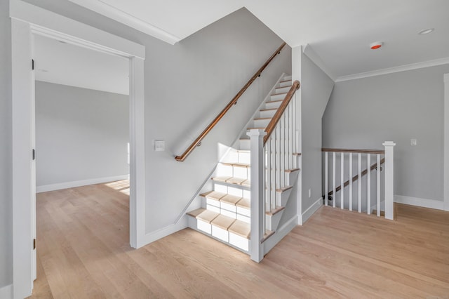 stairs with ornamental molding and hardwood / wood-style flooring