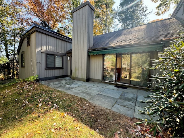 back of house with a chimney and a patio area