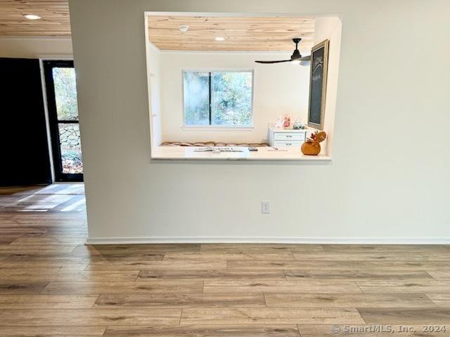 spare room with recessed lighting, baseboards, a wealth of natural light, and wood finished floors