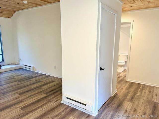 interior space featuring wood ceiling, baseboard heating, and wood finished floors