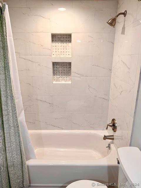 full bath with shower / tub combo and toilet