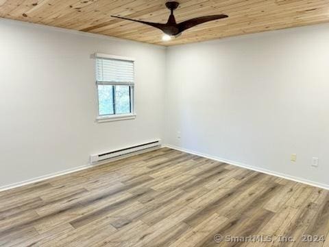 unfurnished room featuring ceiling fan, baseboards, wood finished floors, a baseboard heating unit, and wood ceiling