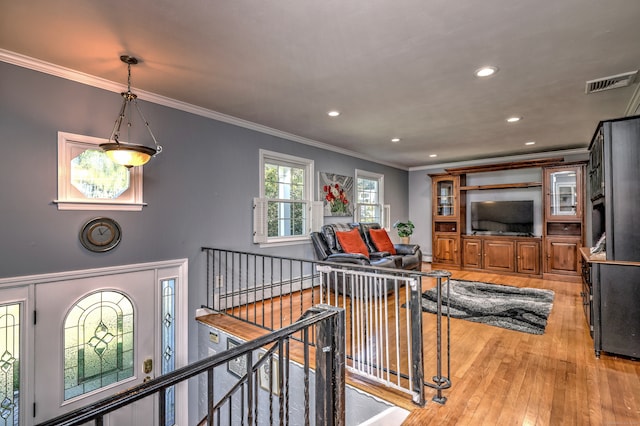 interior space featuring ornamental molding and light wood-type flooring