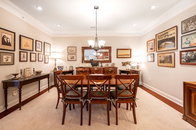 dining space featuring crown molding, light hardwood / wood-style flooring, and a chandelier