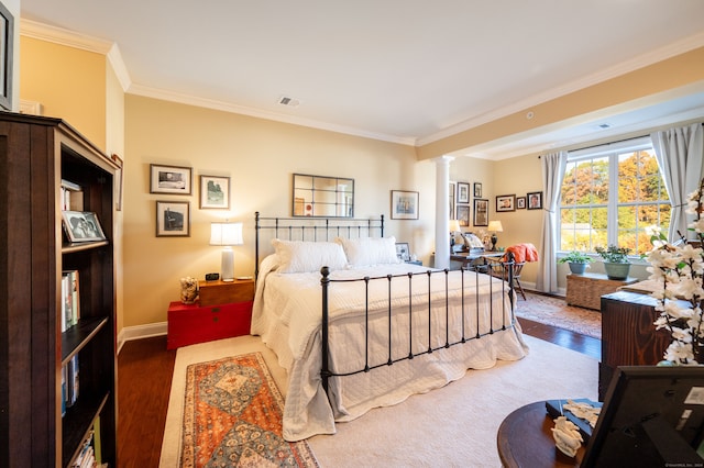 bedroom featuring ornate columns, crown molding, and dark hardwood / wood-style floors