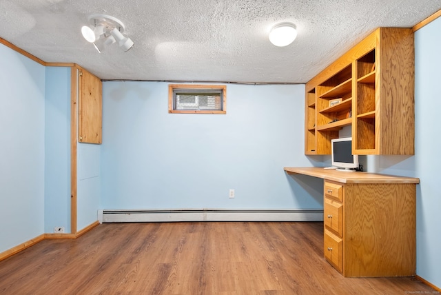 unfurnished office with light hardwood / wood-style flooring, a textured ceiling, and a baseboard radiator