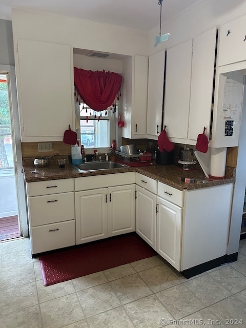 kitchen with white cabinets, plenty of natural light, and sink