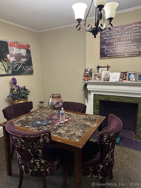 dining area with a chandelier, carpet flooring, a tile fireplace, and ornamental molding