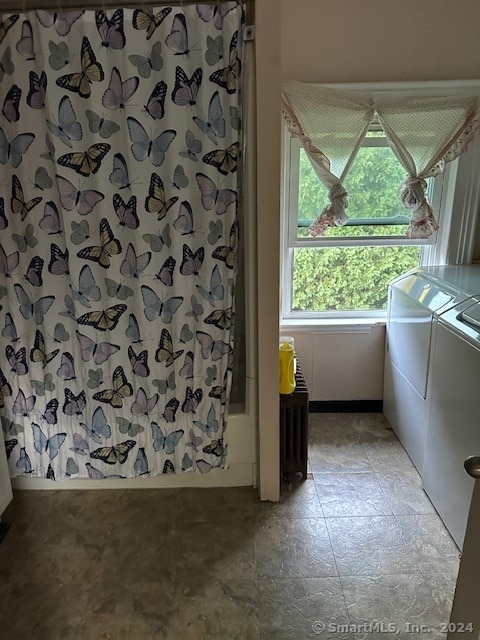 bathroom featuring washer and clothes dryer and radiator