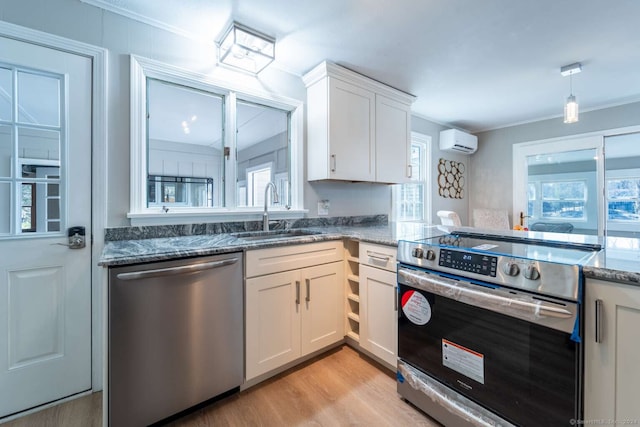 kitchen with sink, a wall mounted AC, stainless steel appliances, and plenty of natural light